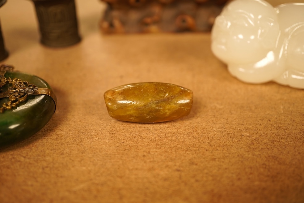 Chinese items comprising a soapstone carving, three jade carvings, one with gilt metal pendant mounts and two brass knops